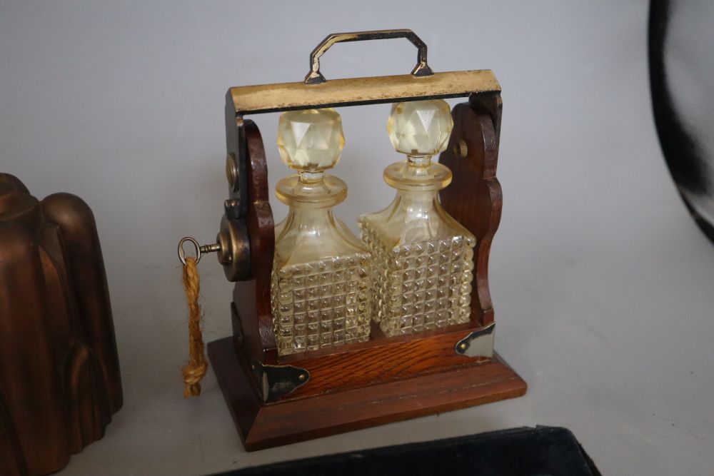A miniature two bottle tantalus, height 17cm, a brass jelly mould and a cased multiplier
